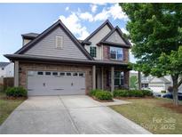 Charming home featuring a two-car garage, stone accents, and manicured landscaping at 159 Saye Pl, Mooresville, NC 28115