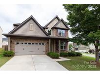 Charming two-story home featuring a brick and siding exterior, well-maintained lawn, and a two-car garage at 159 Saye Pl, Mooresville, NC 28115