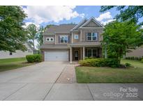 Charming two-story home featuring a brick and siding exterior, well-maintained landscaping, and a two-car garage at 16114 Foreleigh Rd, Huntersville, NC 28078