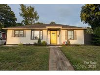 Charming single-story home featuring a bright yellow front door, neutral siding, and a welcoming walkway at 2012 Double Oaks Rd, Charlotte, NC 28206