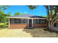 Charming brick home featuring a black roof and black framed windows and newly laid straw in the front yard at 2203 Arney St, Lincolnton, NC 28092