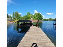 This property features a private dock with a covered boat slip, perfect for enjoying waterfront living at 221 Stillwater Rd, Troutman, NC 28166