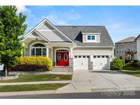 Charming home featuring a gray roof, three car garage, and well-maintained landscaping at 2830 Berkhamstead Cir, Concord, NC 28027