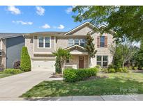 Charming two-story brick home with a well-manicured lawn, landscaping, and an attached two-car garage at 300 Hidden Cove Ln, Matthews, NC 28104