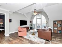 A modern living room featuring hardwood floors, an arched window, and stylish furniture at 300 W 5Th St # 644, Charlotte, NC 28202
