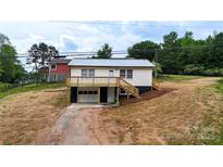 Charming home featuring a metal roof, deck, garage, and inviting curb appeal on a partially landscaped lot at 462 Berry Hill Dr, Norwood, NC 28128