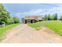 Charming two-story home with a drive-under garage and large wooden deck at 462 Berry Hill Dr, Norwood, NC 28128