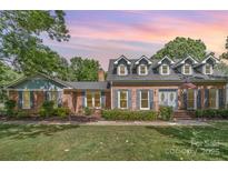 Charming brick home featuring dormer windows and well-maintained landscaping for inviting curb appeal at 6040 Morris Farm Ln, Mint Hill, NC 28227