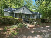 Charming home featuring lovely front yard landscaping including shrubs, flowering plants, and mature shade trees at 622 Neelys Creek Rd, Rock Hill, SC 29732