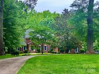 Beautiful brick home with mature trees and a well-manicured lawn offering great curb appeal at 7103 Forest Ridge Rd, Matthews, NC 28104
