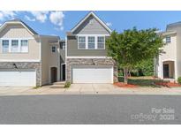 Charming townhome featuring a two-car garage and beautiful stone accents on the facade at 7341 Adare Mews Rd, Charlotte, NC 28217