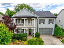 Charming two-story home with a covered porch, balcony, manicured landscaping, and an attached two-car garage at 1020 Forbishire Dr, Matthews, NC 28104