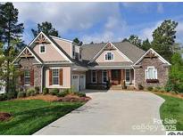 Charming single-story home featuring stone accents, a spacious driveway, and an attached two-car garage at 104 Whiterock Dr, Mount Holly, NC 28120