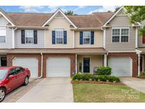 Charming townhouse with tan siding, blue shutters, and a one-car garage in a well-maintained neighborhood at 10617 Fuller Ridge Cir, Charlotte, NC 28270