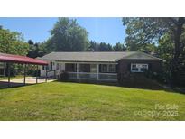 Charming brick home with a covered porch and carport, nestled on a lush lawn at 133 Pine State Rd, Troutman, NC 28166