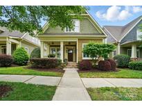 Charming home featuring a quaint front porch, colorful landscaping, and a neatly maintained lawn at 15714 Laurel Oak Cres, Davidson, NC 28036