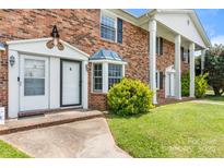 Brick two-story townhome with white door trim, bay window, and landscaped yard at 160 17Th Street Nw Pl, Hickory, NC 28601
