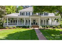 Stately white home with inviting front porch, black shutters, and manicured lawn at 18705 Harbor Light Blvd, Cornelius, NC 28031
