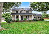 Charming two-story home with a welcoming front porch and well-manicured lawn and trimmed bushes at 188 Turnberry Ln, Mooresville, NC 28117