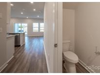 Modern powder room featuring a white toilet and neutral wall paint, conveniently located near the home's living area at 4213 Summit Woods Dr, Charlotte, NC 28216