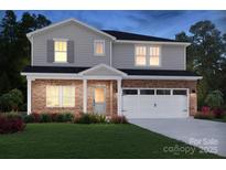 Charming two-story home featuring brick accents, a two-car garage, and a well-manicured lawn with fresh flowers at 425 Bent Burr Crk, York, SC 29745