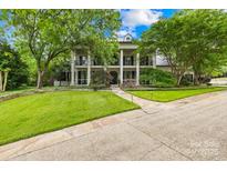 Stately home with a large front yard, mature trees, and a circular driveway at 4523 Fox Brook Ln, Charlotte, NC 28211