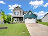 Beautiful two-story home with a well-manicured lawn, two-car garage, and a welcoming covered front porch at 6381 Trinity Crossing Cir, Kannapolis, NC 28081