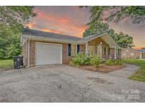 Charming brick home featuring an attached garage, well-maintained landscaping, and a welcoming front entrance at 6573 Weldon Nw Cir # 22, Concord, NC 28027