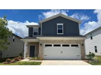 Charming two-story home features a brick and blue vinyl exterior with an attached two-car garage at 820 Blue Canyon Dr, York, SC 29745