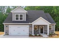 Charming home with gray siding, a white garage door, and well-maintained landscaping at 908 Westminster Dr, Statesville, NC 28677