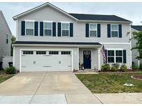 Charming two-story home with light gray siding, a two-car garage, and an inviting navy blue front door at 115 Crownpiece St, Troutman, NC 28166