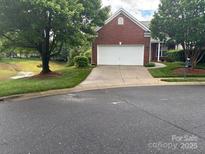 Charming brick home featuring a well-manicured lawn and an attached two-car garage at 1678 Onyx Rdg, Fort Mill, SC 29708