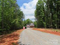 A new two-story home with a gravel driveway nestled among lush green trees at 2099 Cedar Rd, York, SC 29745