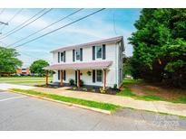 Charming two-story home with a front porch, black shutters, and a well-maintained yard, situated on a tree-lined street at 210 W 15Th St, Newton, NC 28658