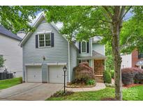 Charming two-story home featuring a two-car garage and a beautifully landscaped front yard, enhanced by mature trees at 2100 Sablewood Dr, Charlotte, NC 28205
