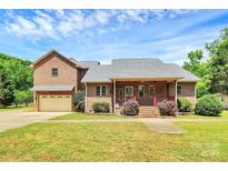 Charming brick home with a welcoming front porch and well-maintained landscaping under a partly cloudy sky at 261 Melrose Sw Dr, Concord, NC 28025