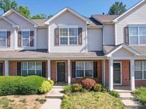 Traditional townhome featuring a brick facade, neutral siding and well-maintained landscaping at 3055 Golden Dale Ln # 104, Charlotte, NC 28262