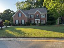 Traditional two-story brick home with a well-manicured lawn and mature trees at 4066 Belle Meade Cir, Belmont, NC 28012