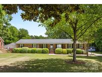 Charming single-story brick home with lush green lawn and manicured hedges in a desirable neighborhood at 4600 Beatties Ford Rd, Charlotte, NC 28216