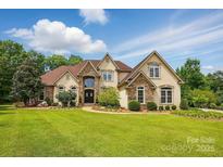 Stunning home featuring stone accents, a well-manicured lawn, and professionally landscaped greenery at 581 Medora Ln, Fort Mill, SC 29708