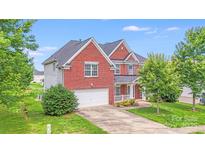 Charming two-story brick home with a well-manicured lawn and an attached two-car garage at 6227 Castlecove Rd, Charlotte, NC 28278