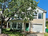 Charming two-story home with a well-maintained lawn, attached garage, and decorative green shutters at 7307 Mitzi Deborah Ln, Charlotte, NC 28269