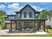 Charming two-story home boasts a covered front porch with seating, a beautiful lawn, and a two-car garage at 922 Everett Pl, Charlotte, NC 28205