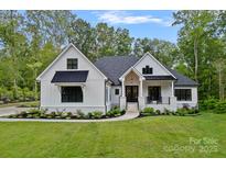 Charming two-story home with a manicured lawn and elegant landscaping at 9564 Regent Dr, Davidson, NC 28036