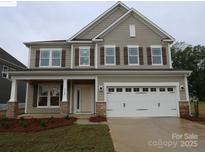 Charming two-story home with stone accents, brown shutters, a covered front porch, and a two-car garage at 9920 Emerson Glen Dr, Kannapolis, NC 28027