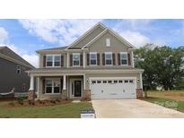Two-story home featuring a two car garage, craftsman style columns, and a manicured front lawn at 9920 Emerson Glen Dr, Kannapolis, NC 28027