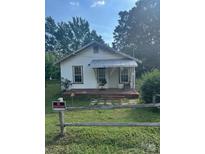 Quaint one-story home with covered porch and mature trees at 126 N Kendall St, Norwood, NC 28128