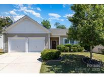 Charming home featuring a well-manicured lawn, neatly trimmed shrubs, and a convenient two-car garage at 12792 Clydesdale Dr, Midland, NC 28107