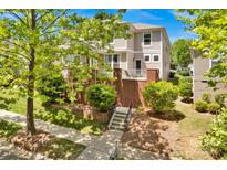 Charming two-story home with brick accents, lush landscaping, and a inviting front porch at 14940 Carbert Ln, Huntersville, NC 28078