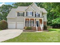 Charming two-story home features a well-manicured lawn, two-car garage, and inviting front porch at 15108 Castlebridge Ln, Matthews, NC 28104